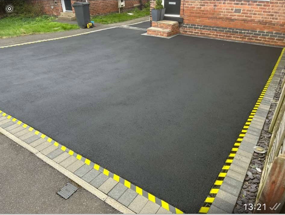Freshly restored black tarmac driveway by Top Gun & Son